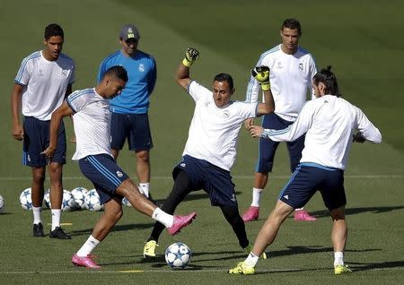 Real Madrid's goalkeeper Keylor Navas (C) controls the ball between Casemiro (L) and Gareth Bale during a training session ahead of their Champions League soccer match against Shakhtar Donetsk at the team's training camp outside Madrid, Spain, September 14, 2015. REUTERS/Andrea Comas