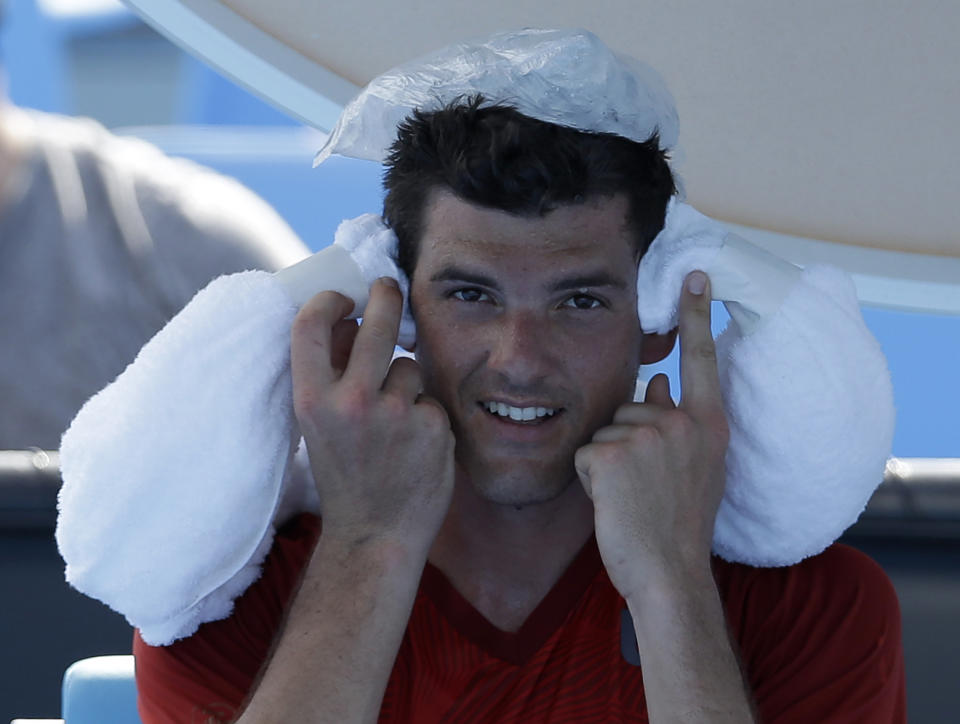 Frank Dancevic of Canada applies an ice pack to his head after collapsing during his first round match against Benoit Paire of France Tuesday, Jan. 14, 2014. (AP Photo/Aijaz Rahi)