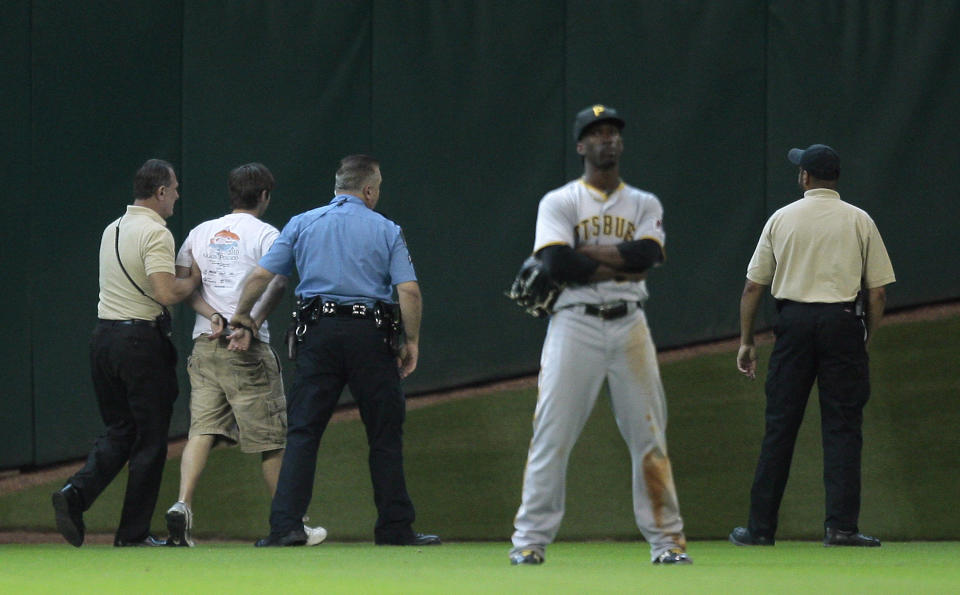 Security and Houston Police apprehend a fan that ran onto the field during a baseball game between the Pittsburgh Pirates and Houston Astros at Minute Maid Park on July 8, 2010 in Houston, Texas. (Photo by Bob Levey/Getty Images)