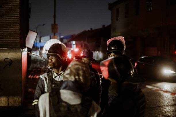 A group of private security guards gather near the entrance of a burned apartment block in Johannesburg on 31 August 2023 (AFP via Getty Images)