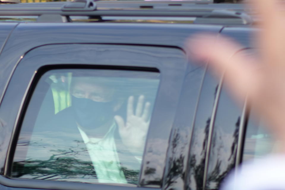 FILE - In this Sunday, Oct. 4, 2020 file photo, President Donald Trump drives past supporters gathered outside Walter Reed National Military Medical Center in Bethesda, Md. Trump was admitted to the hospital after contracting COVID-19. On Friday, Oct. 9, 2020, The Associated Press reported on stories circulating online incorrectly asserting that while hospitalized, Trump said, “The doctors said they’ve never seen a body kill the coronavirus like my body. They tested my DNA and it wasn’t DNA. It was USA.” There is no evidence Trump made such a statement. (AP Photo/Anthony Peltier)