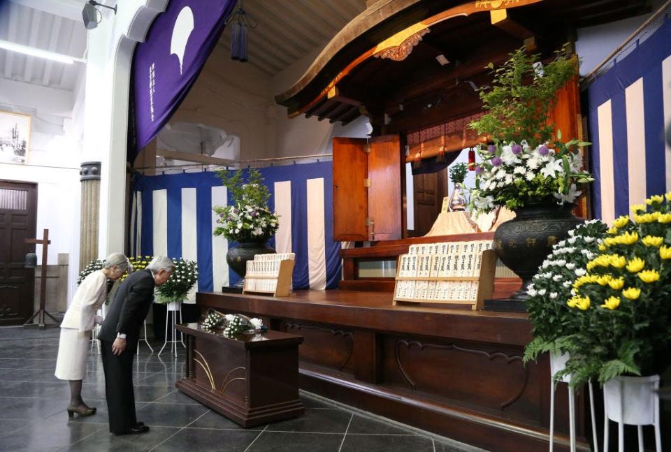 Japan's Emperor Akihito (R) and Empress Michiko bow after placing flowers as offerings at Tokyo Memorial Hall in Tokyo