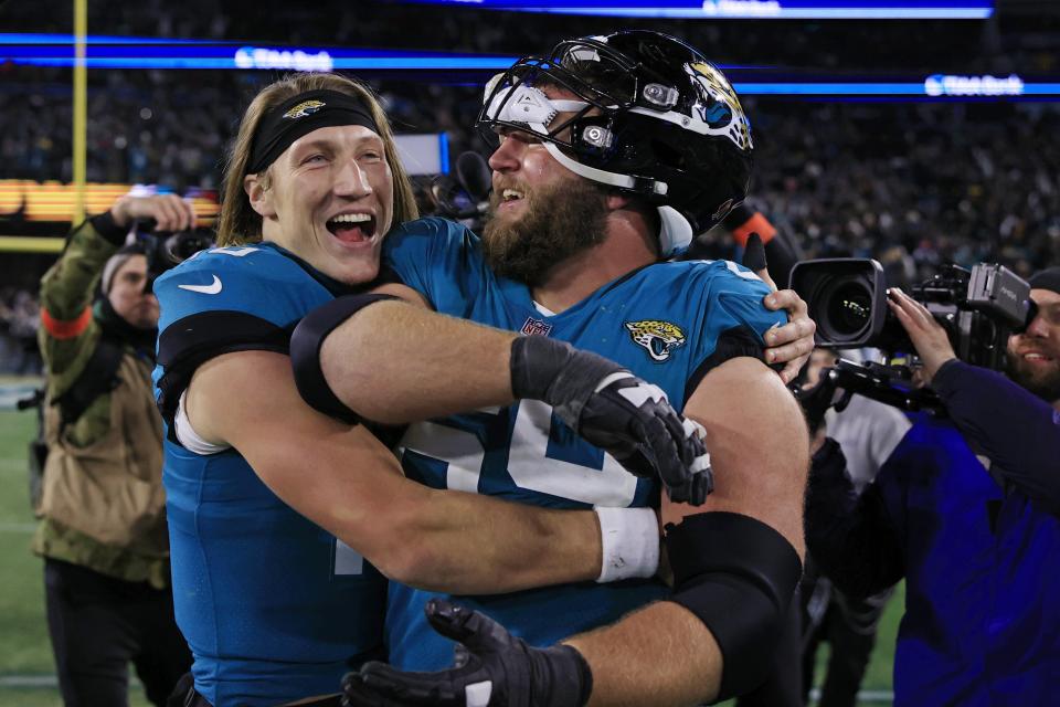 Jacksonville Jaguars quarterback Trevor Lawrence (16), left, hugs center Tyler Shatley (69) after the game of an NFL first round playoff football matchup Saturday, Jan. 14, 2023 at TIAA Bank Field in Jacksonville, Fla. Jacksonville Jaguars edged the Los Angeles Chargers on a field goal 31-30. [Corey Perrine/Florida Times-Union]