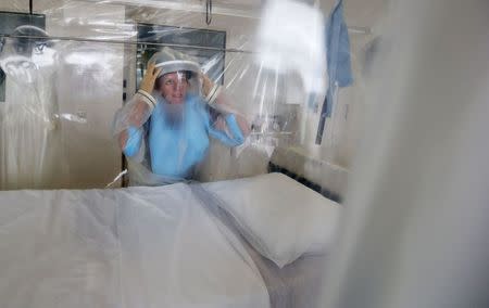 File photograph shows senior Matron Breda Athan demonstrates putting on the protective suit which would be used if it becomes necessary to treat patients suffering from Ebola, at The Royal Free Hospital in London August 12, 2014. REUTERS/Suzanne Plunkett/Files