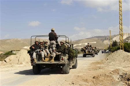 Lebanese army soldiers on their military vehicles enter the Sunni Muslim border town of Arsal, in eastern Bekaa Valley March 19, 2014. REUTERS/Hassan Abdallah