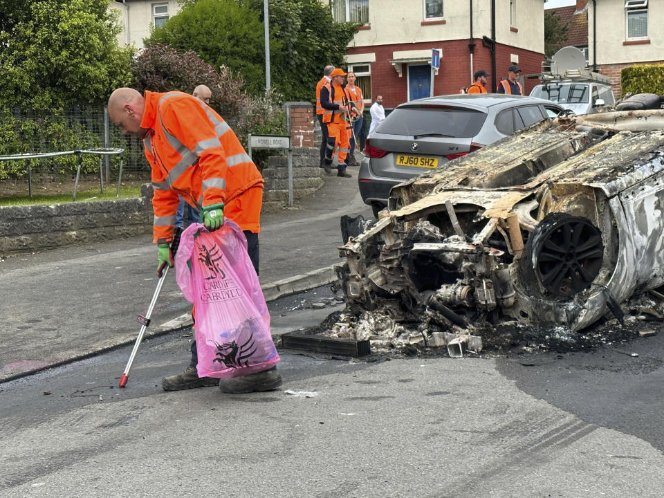 A burnt vehicle is seen at the scene where a riot broke out after two teenagers died in a crash, in Ely, Cardiff, Tuesday May 23, 2023. Several dozen youths pelted police with objects and set cars ablaze on Monday evening in Cardiff in local unrest that erupted after two teenagers died in a road accident. (PA via AP)