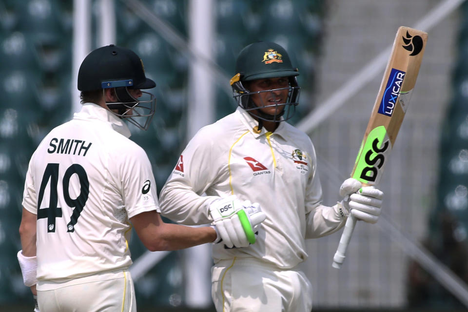 Australia's Usman Khawaja, right, celebrates after completing 50 runs on the first day of the third test match between Pakistan and Australia at the Gaddafi Stadium in Lahore, Pakistan, Monday, March 21, 2022. (AP Photo/K.M. Chaudary)