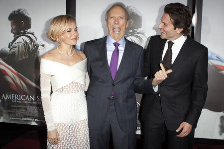 Actress Sienna Miller (L), director Clint Eastwood and actor Bradley Cooper ( R) arrive for the premiere of the film "American Sniper" in New York, December 15, 2014. REUTERS/Carlo Allegri