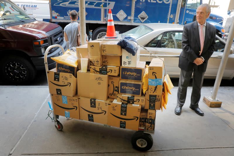 FILE PHOTO: A delivery cart loaded with a number of packages from Amazon stands on a sidewalk in New York City