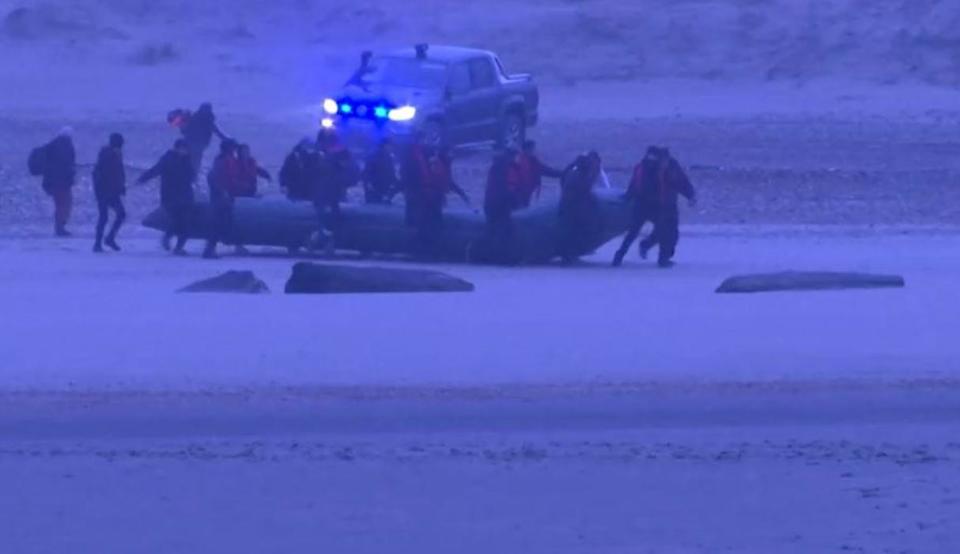 Migrants push an inflatable boat into the English Channel from a beach near the town of Wimereux, on the far northern French coast - one of the narrowest points between France and the southern coast of Britain - as a French police vehicle is seen in the background, November 24, 2021. / Credit: Reuters