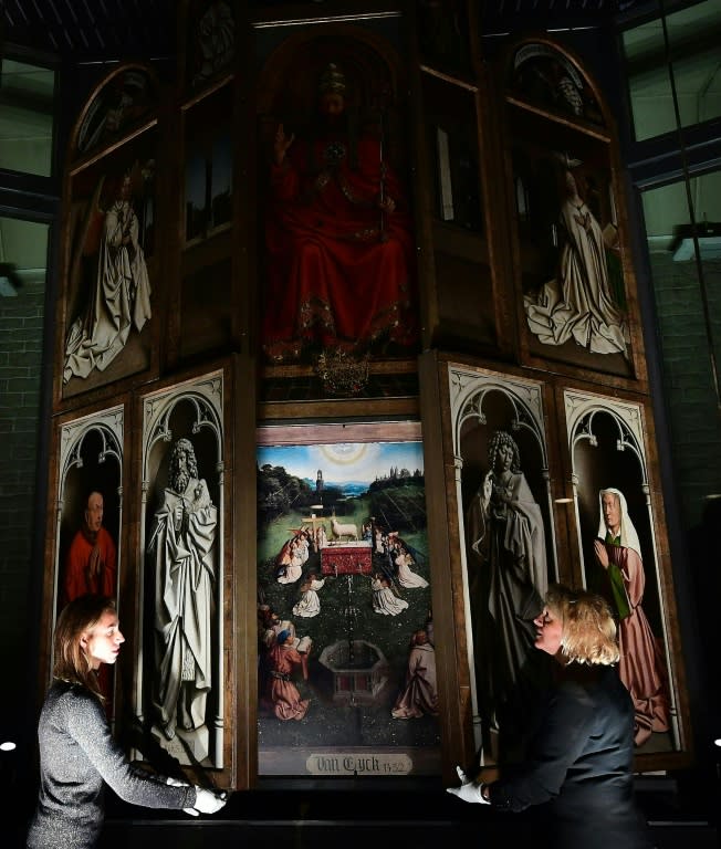 Officials show off the interior of "The Adoration of the Mystic Lamb" by the Van Eyck brothers, a 15th-century artwork that for years was obscured by layers of dirt and alterations