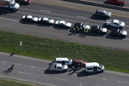 Law enforcement personnel investigate the scene where the Texas bombing suspect blew himself up on the side of a highway north of Austin in Round Rock, Texas, U.S., March 21, 2018. REUTERS/Loren Elliott