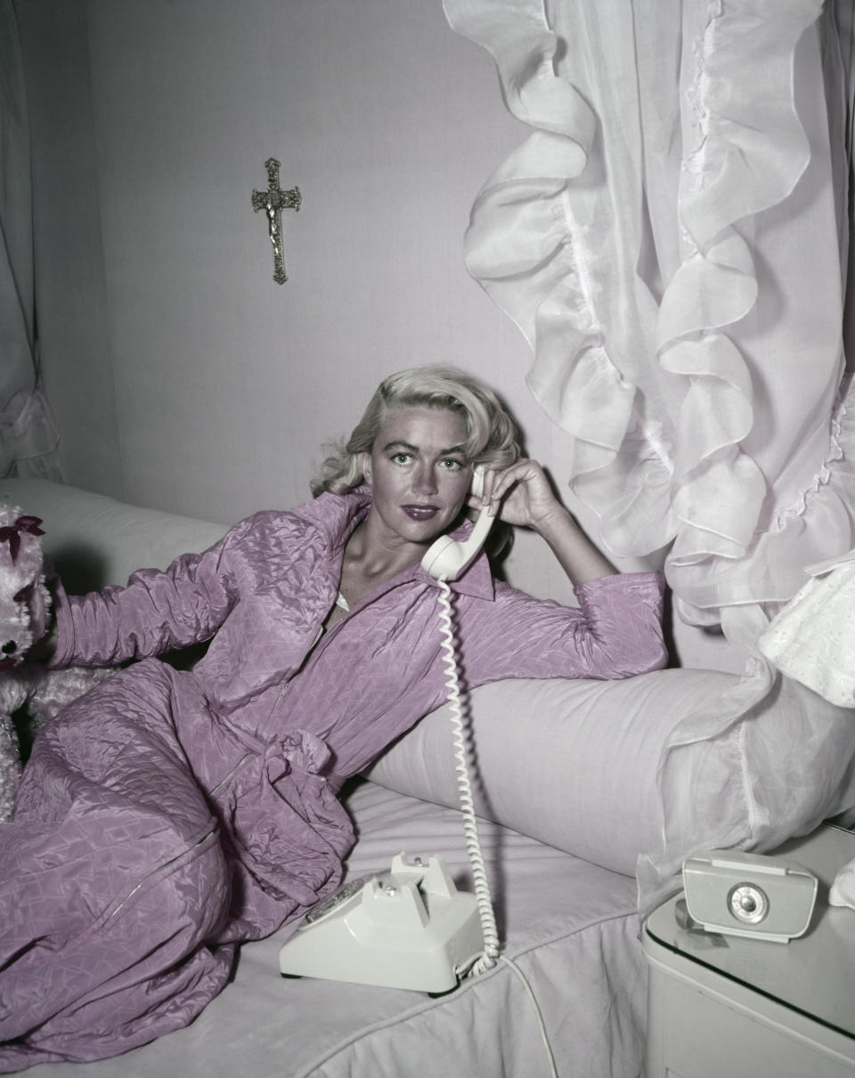 Malone wears a pink dressing gown while on the phone, circa 1955.&nbsp;