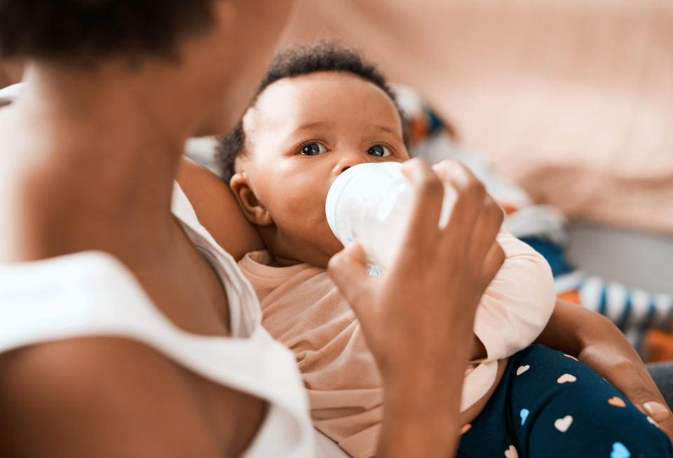 Shot of a mother feeding her adorable infant daughter at home