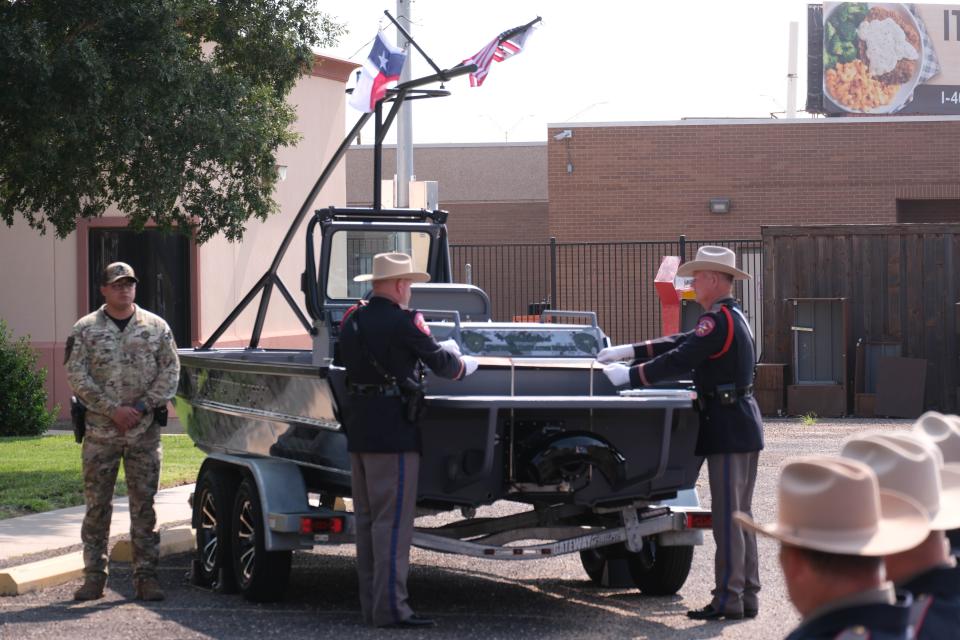 DPS officers unveil the official name placard at the boat dedication ceremony for Trooper Matthew Myrick Friday morning at the Texas Panhandle War Memorial Center in Amarillo.