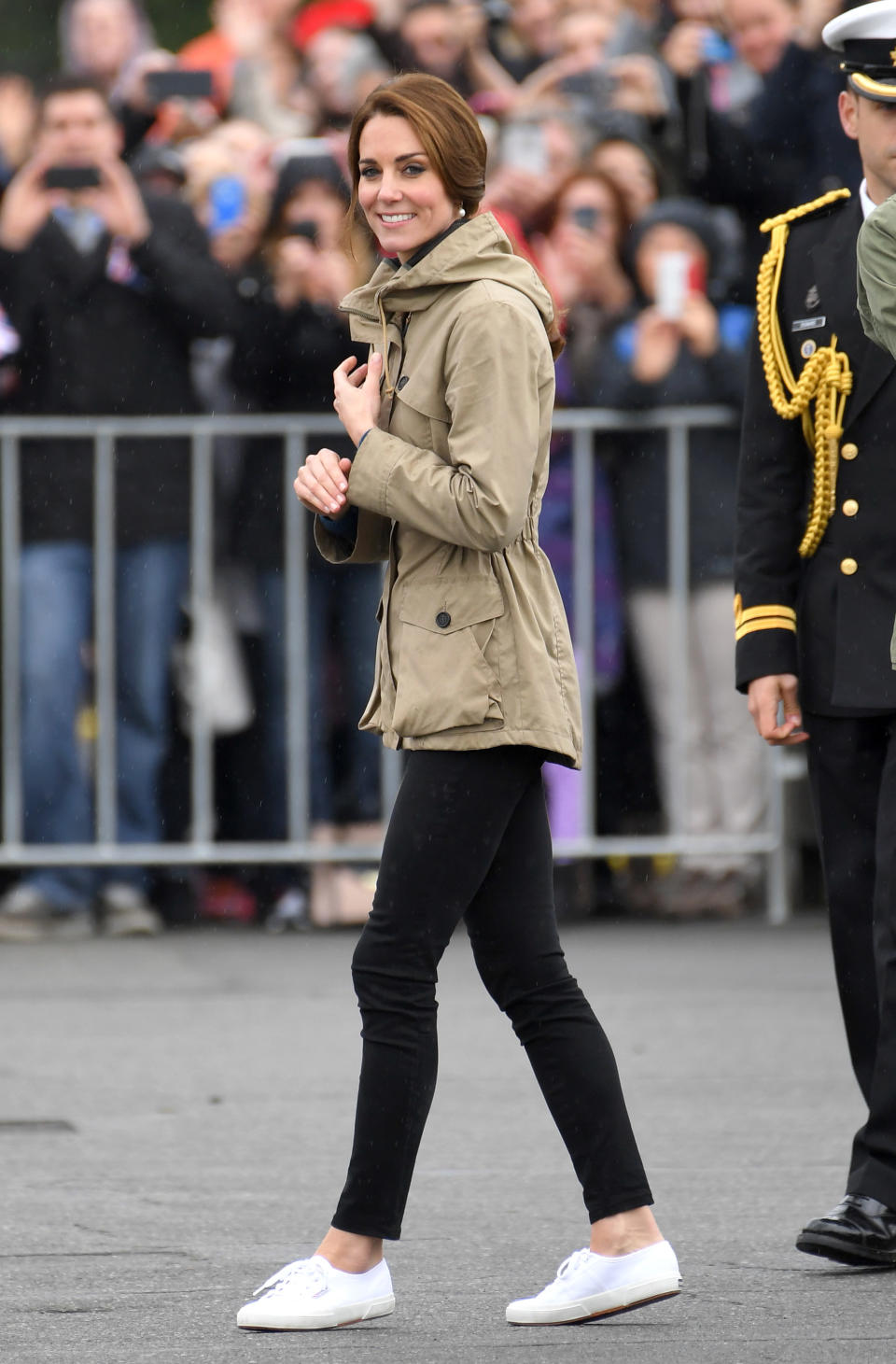 kate middleton wearing white superga sneakers, black skinny jeans, and a tan coloured jacket at an event