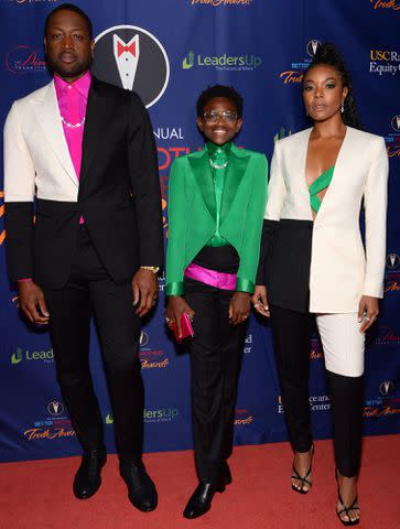 Andrew Toth/Getty Images Dwayne Wade (left) poses on the red carpet with daughter Zaya and wife Gabrielle Union.