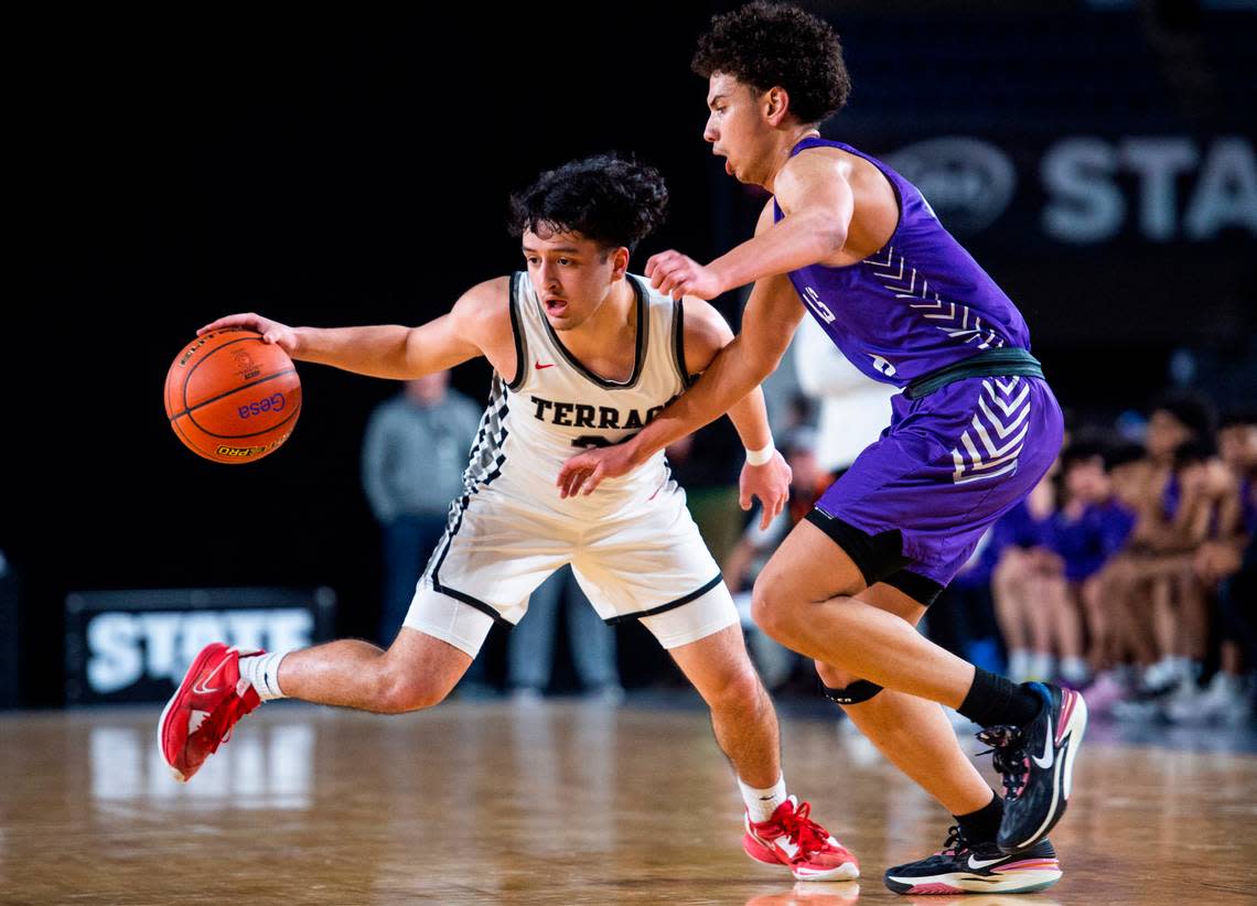 Mountlake Terrace guard Logan Tews (21) drives down the court past North Thurston guard Micah Anderson (11) during an opening round game at the WIAA state basketball tournament in the Tacoma Dome in Tacoma, Washington, on Wednesday, March 1, 2023. Mountlake Terrace won the game 58-53. 