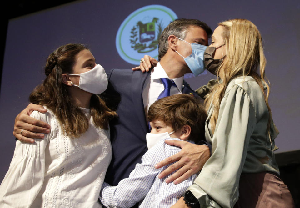 Venezuelan opposition leader Leopoldo Lopez kisses his wife Lilian Tintori with their son and daughter after a news conference in Madrid on Tuesday, Oct. 27, 2020. Prominent opposition activist Leopoldo López who has abandoned the Spanish ambassador's residence in Caracas and left Venezuela after years of frustrated efforts to oust the nation's socialist president is holding a news conference in Madrid. (AP Photo/Andrea Comas)