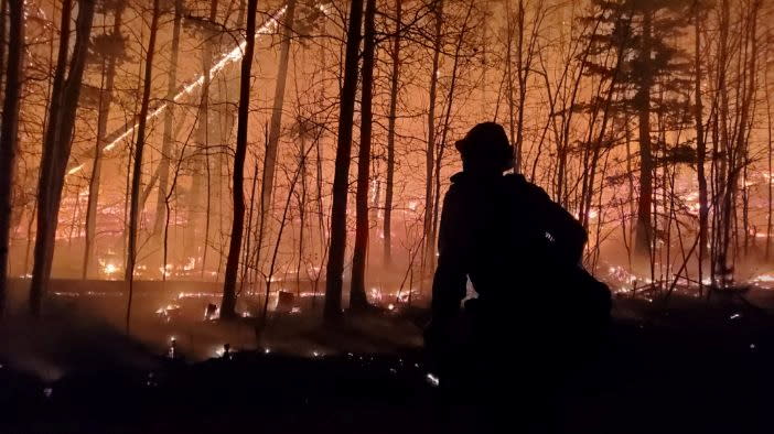 A firefighter is silhouetted as Cameron Peak Fire, the largest wildfire in Colorado's history, burns outside Drake, Colorado, US.