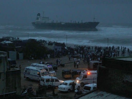 Ambulances and police vehicles are seen on the beachfront after the oil tanker ship Pratibha Cauvery ran aground off the coast in Chennai. Thousands of people evacuated from their homes in southeast India Wednesday as a cyclone slammed into the coast, killing two people, according to reports, and causing an oil tanker to run aground