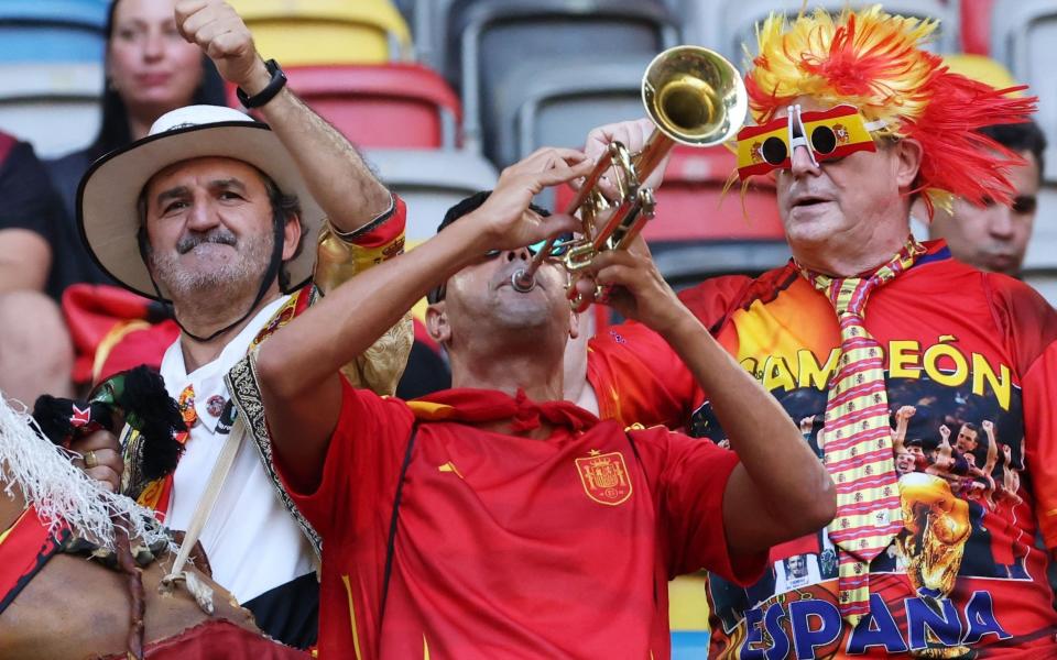 A Spain fan adds some musical accompaniment to proceedings