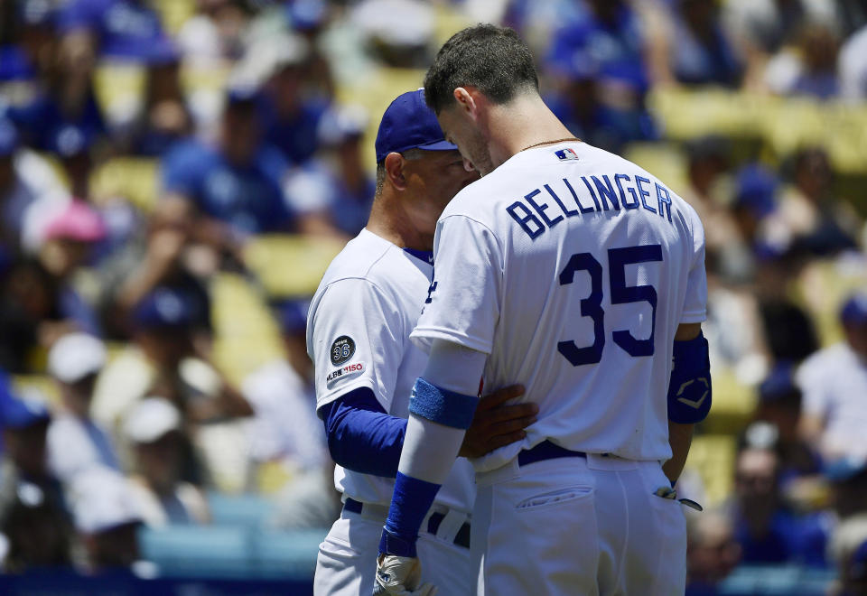 Los Angeles Dodgers manager Dave Roberts, left, talks with Cody Bellinger after Bellinger hit a fan with a foul ball during the first inning of a baseball game against the Colorado Rockies, Sunday, June 23, 2019, in Los Angeles. (AP Photo/Mark J. Terrill)