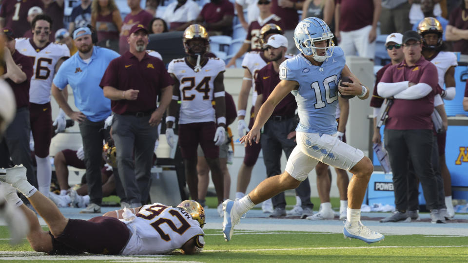 Minnesota defensive lineman Danny Striggow (92) dives but misses North Carolina quarterback Drake Maye (10) who runs the ball during the second half of an NCAA college football game, Saturday, Sept. 16, 2023, in Chapel Hill, N.C. (AP Photo/Reinhold Matay)