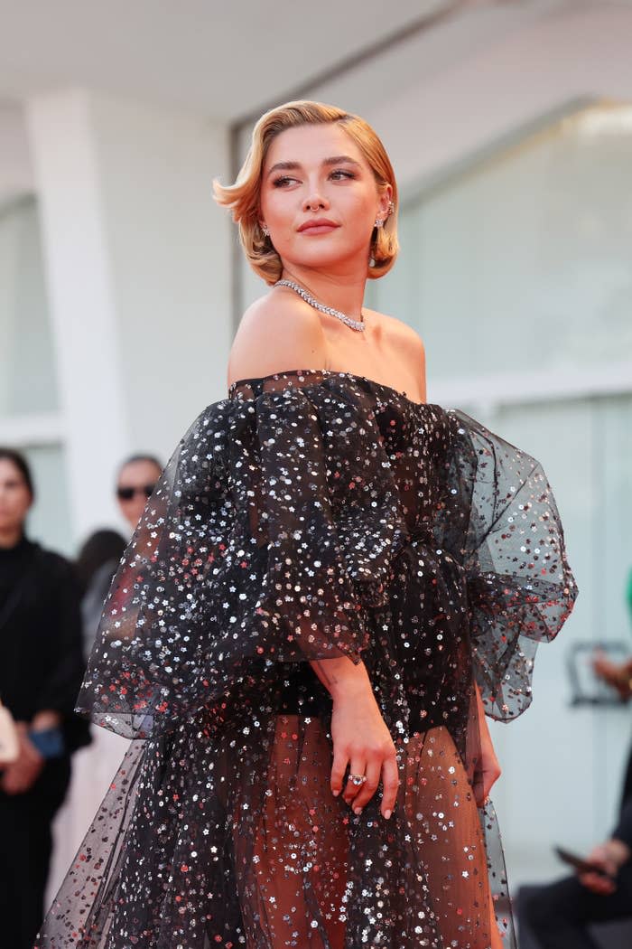 Florence at a red carpet premiere wearing a sheer, off-the-shoulder dress with sequins