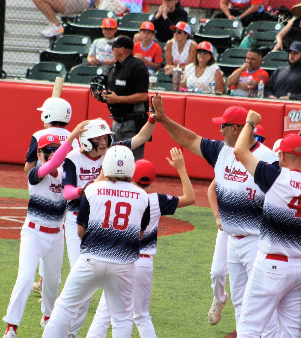 Dover's Owen Lovering is congratulated by teammates and coaches after scoring on his inside-the-park home run in Tuesday's 7-4 loss to Windsor, California at the Cal Ripken World Series in Branson, Missouri.