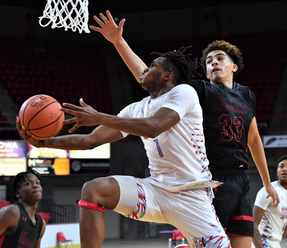 Hirschi's Jamarion Carroll reaches around Amarillo Tascosa's Jailyn Sledge for the basket during the Wichita Falls Classic Basketball Tournament at Kay Yeager Coliseum on Saturday, December 17, 2022.