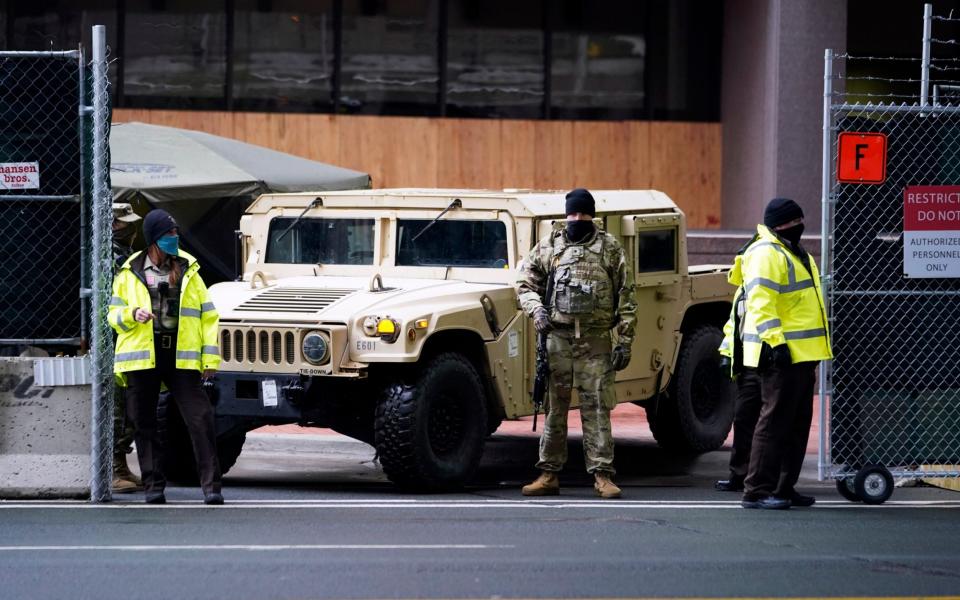 A National Guard soldier stands guard outside the courthouse - Jim Mone/AP 