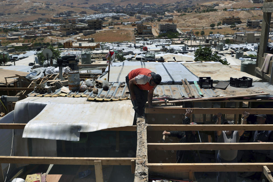 In this Sunday, June 16, 2019 photo, Syrian refugees demolish a concrete wall built inside their tent at a refugee camp in the eastern Lebanese border town of Arsal, Lebanon. Authorities in Lebanon are waging their most aggressive campaign yet against Syrian refugees, making heated calls for them to go back to their country and taking action to ensure they can’t put down roots. They are shutting down shops where Syrians work without permits and ordering the demolition of anything in their squalid camps that could be a permanent home. (AP Photo/Bilal Hussein)