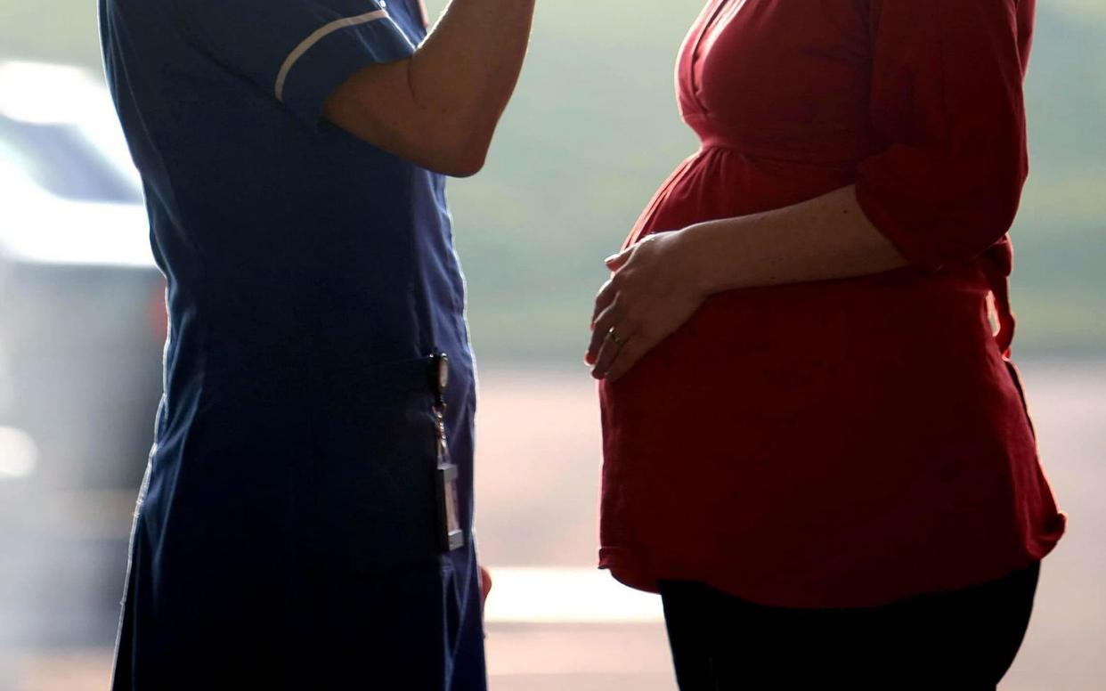 Midwife talking to a pregnant woman - David Jones /PA