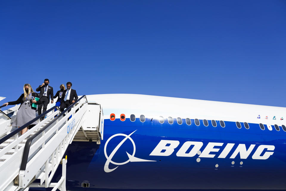 Boeing staffers come off a Boeing 777X on display at the Dubai Air Show in Dubai, United Arab Emirates, Sunday, Nov. 14, 2021. The biennial Dubai Air Show opened Sunday as commercial aviation tries to shake off the coronavirus pandemic. (AP Photo/Jon Gambrell)