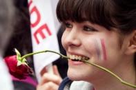 A young supporter with a rose in her mouth waits with other supporters in front of the campaign headquarters of the Socialist Party (PS) in Paris, during the presidential election second round vote