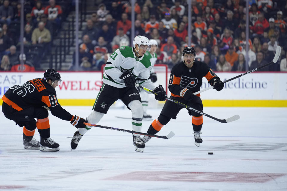 Dallas Stars' Jason Robertson (21) battles for the puck with Philadelphia Flyers' Joel Farabee (86) and Morgan Frost (48) during the first period of an NHL hockey game, Sunday, Nov. 13, 2022, in Philadelphia. (AP Photo/Matt Slocum)