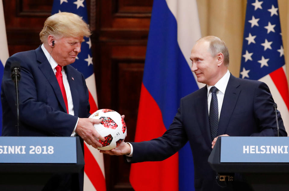 U.S. President Donald Trump receives a football from Russian President Vladimir Putin as they hold a joint news conference after their meeting in Helsinki, Finland July 16, 2018. (Photo: REUTERS/Grigory Dukor)