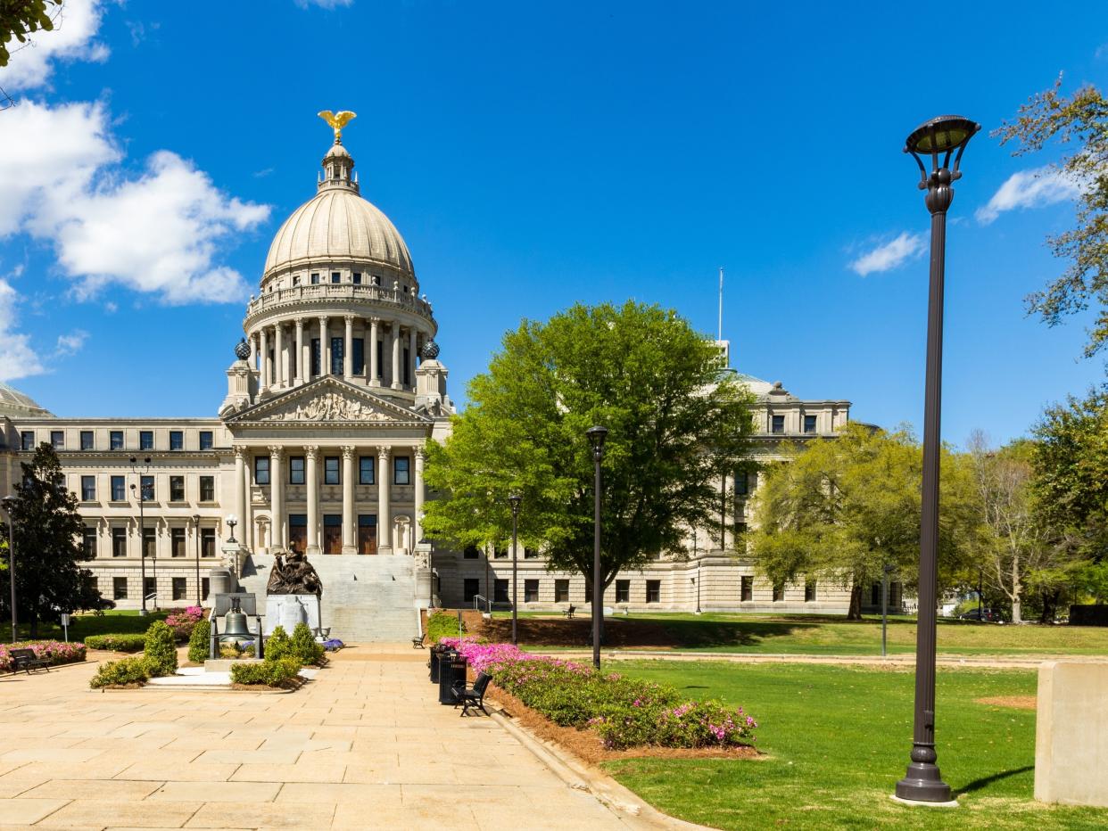 The exterior of the Mississippi Capitol with gardens in front of it.