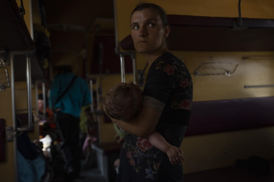 Internally displaced from Sloviansk, 26-year old Nataliia Tkachenko, holds her 8-month old son Oleksii, on a train leaving to Dnipro, in the Pokrovsk train station, Donetsk region, eastern Ukraine, Wednesday, July 6, 2022. Many are responding to the authorities' pleas to evacuate. As Russian troops march west, a steady flow of people continue to evacuate from towns caught in the crosshairs of the war, with hundreds leaving on a daily evacuation train from Pokrovsk. (AP Photo/Nariman El-Mofty)