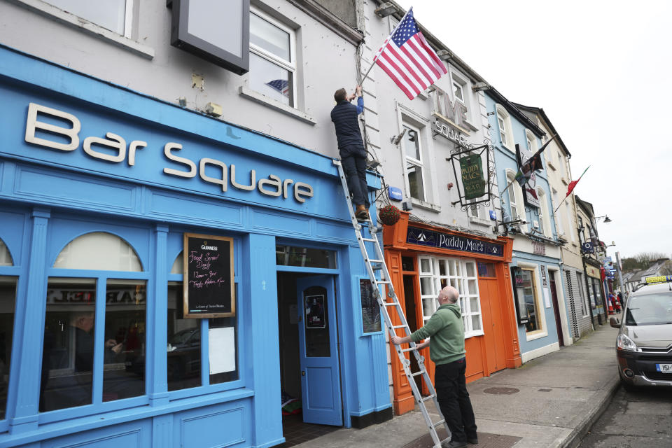 Publicans put up U.S flags outside the Blue Square bar in Ballina, Ireland, Tuesday, April 4, 2023. Excitement is building in Ballina, a small Irish town that was home to some of President Joe Biden's ancestors. Biden is scheduled to visit the town next week, part of a four-day trip to Ireland and neighboring Northern Ireland.(AP Photo/Peter Morrison)