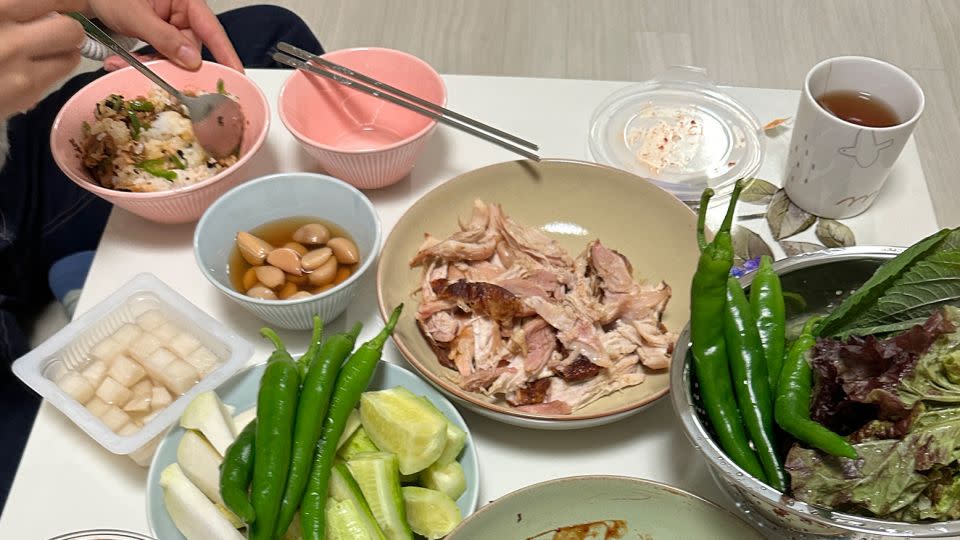 Chae-ran prepared dinner at home in South Korea, sitting on the floor as she ate. - Yoonjung Seo/CNN