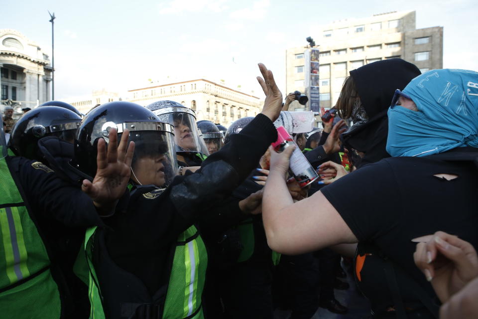 Manifestantes feministas chocan con mujeres policías durante una protesta por el asesinato de dos activistas en Ciudad de México, el sábado 25 de enero de 2020. (AP Foto/Ginnette Riquelme)