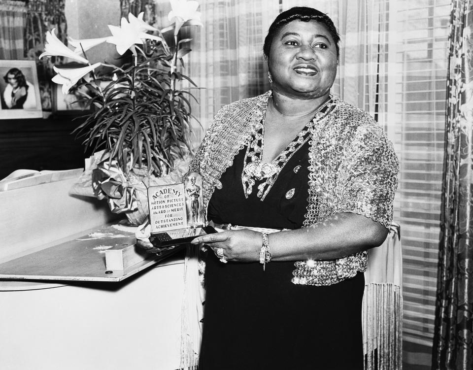 American actress Hattie McDaniel (1895 - 1952) with her Academy Award of Merit for Outstanding Achievement, circa 1945. McDaniel won an Oscar for Best Supporting Actress for her role of Mammy in 'Gone With The Wind', making her the first African-American to win an Academy Award. 