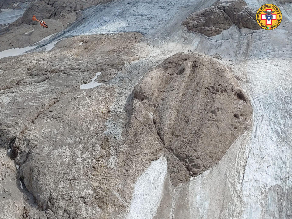 This image released on Sunday, July 3, 2022, by the Italian National Alpine and Cave Rescue Corps shows the glacier in Italy's Alps near Trento a large chunk of which has broken loose, killing at least six hikers and injuring eight others. Alpine rescue service officials, which provided that toll Sunday evening, said it could take hours to determine if any hikers might be missing. The National Alpine and Cave Rescue Corps tweeted that the search of the involved area of Marmolada peak involved at least five helicopters and rescue dogs. (Corpo Nazionale Soccorso Alpino e Speleologico via AP)