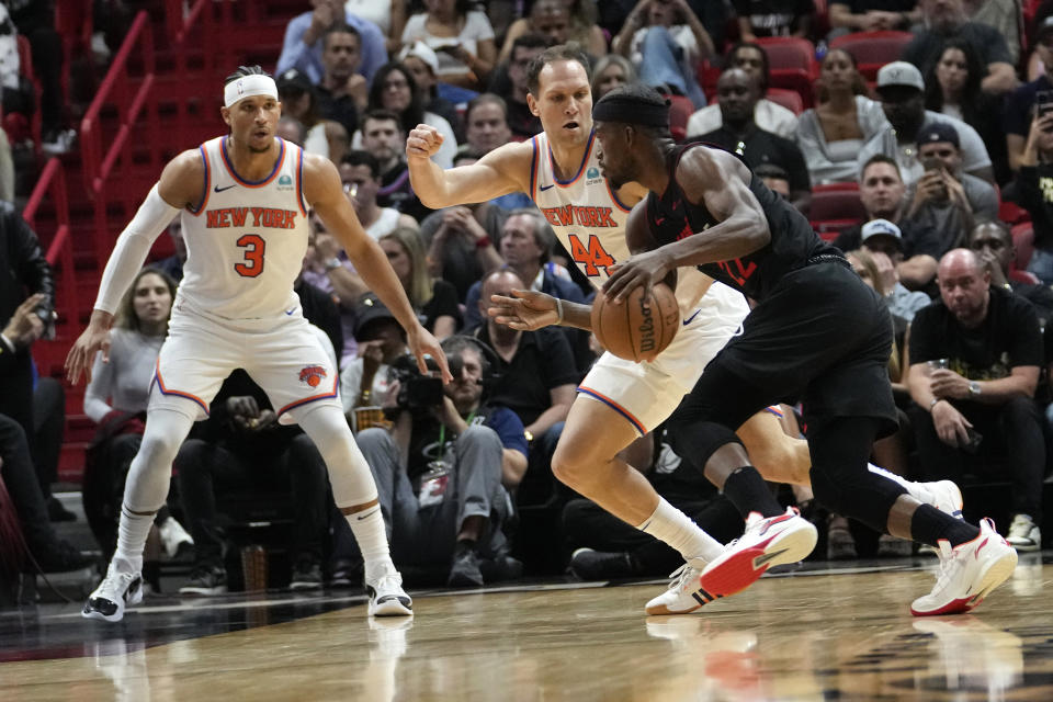 Miami Heat forward Jimmy Butler, right, drives to the basket as New York Knicks guard Josh Hart (3) and forward Bojan Bogdanovic (44) defend during the first half of an NBA basketball game, Tuesday, April 2, 2024, in Miami. (AP Photo/Lynne Sladky)