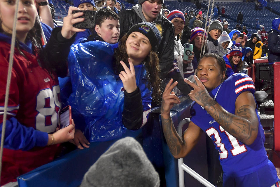 Buffalo Bills cornerback Rasul Douglas (31) poses for photos with fans after playing against the Dallas Cowboys in an NFL football game, Sunday, Dec. 17, 2023, in Orchard Park, N.Y. (AP Photo/Adrian Kraus)