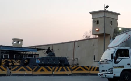 A truck drives in front of security and riot police guards, outside Cairo's Tora prison, where the trial of ousted Egyptian Islamist President Mohamed Mursi took place, in Cairo