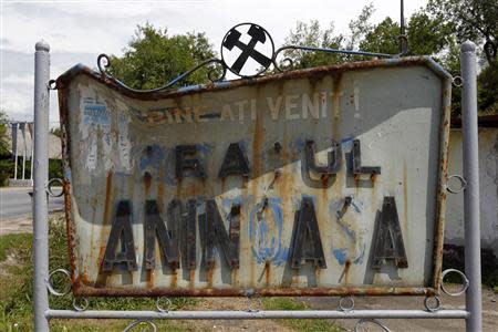 An obsolete traffic sign welcomes visitors to Aninoasa, 330 km (202 miles) west of Bucharest July 31, 2013. REUTERS/Bogdan Cristel