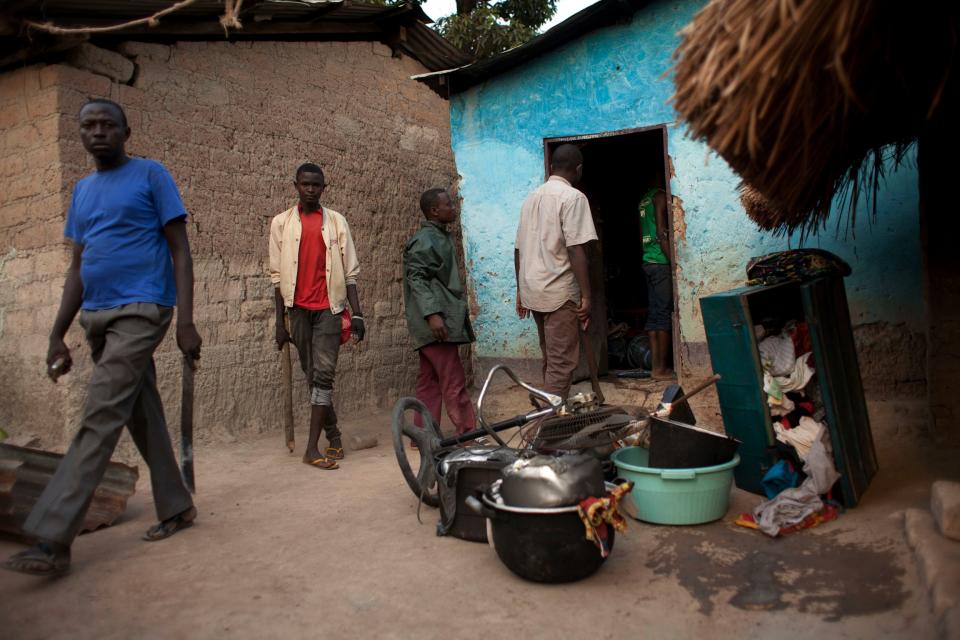 Residents who returned from a makeshift camp for the displaced at Mpoko Airport to fetch household goods remove personal items from a burned home, in Bangui, Central African Republic, on New Year's Day, Wednesday, Jan. 1, 2014. Clashes between armed gangs of Muslim and Christian residents continued in the 5th Arrondissement on Wednesday, with neighborhood residents reporting at least four people killed. In Garaba, several homes belonging to Christians were burned, and multiple Muslim homes looted. (AP Photo/Rebecca Blackwell)